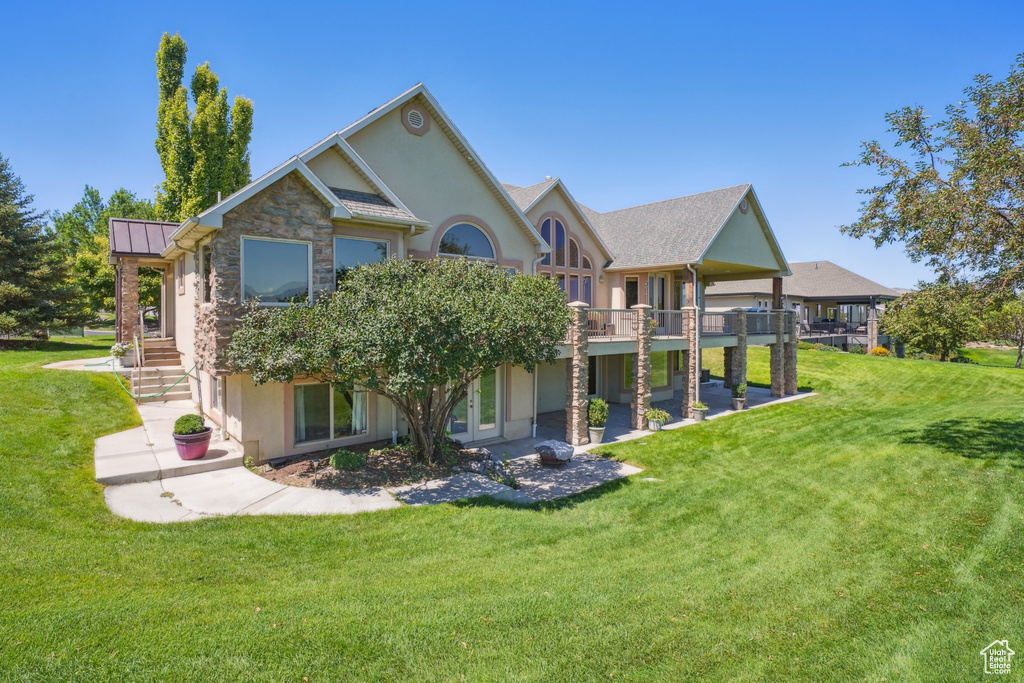 Rear view of house featuring a lawn