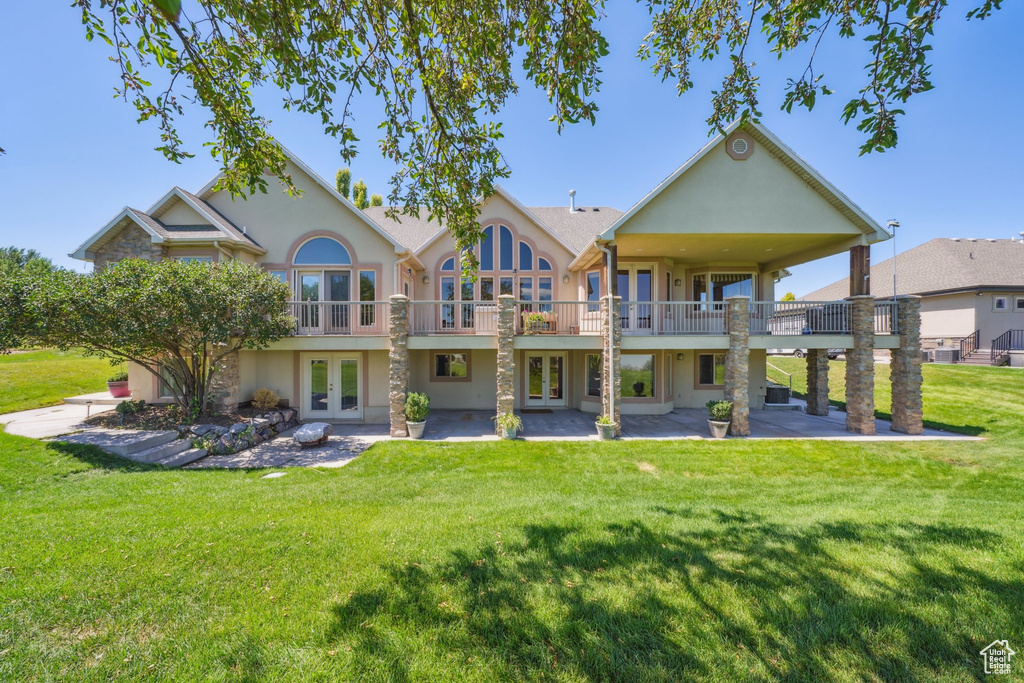 Rear view of house with french doors, a yard, and a patio area