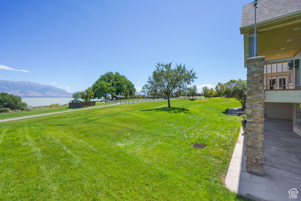 View of yard with a balcony and a water and mountain view