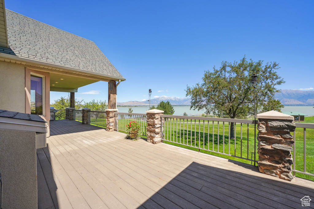 Wooden terrace with a water and mountain view and a lawn