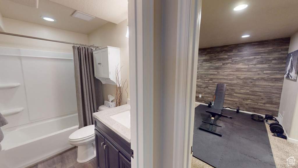 Full bathroom featuring shower / bath combo with shower curtain, hardwood / wood-style floors, toilet, and vanity