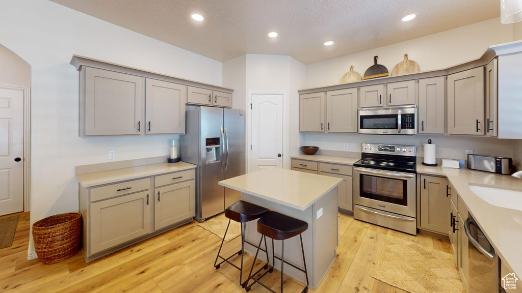 Kitchen with a center island, stainless steel appliances, and light hardwood / wood-style floors