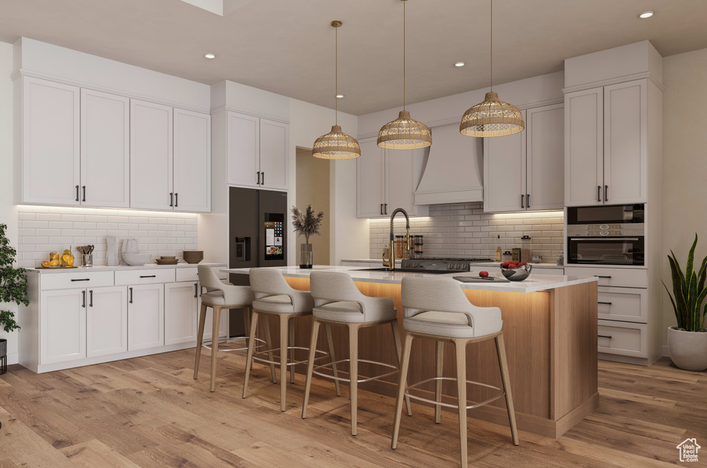 Kitchen featuring light wood-type flooring, pendant lighting, and white cabinets