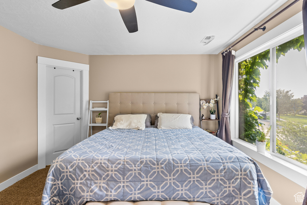 Carpeted bedroom featuring ceiling fan