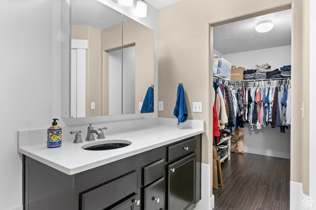 Bathroom with hardwood / wood-style flooring, a textured ceiling, and vanity