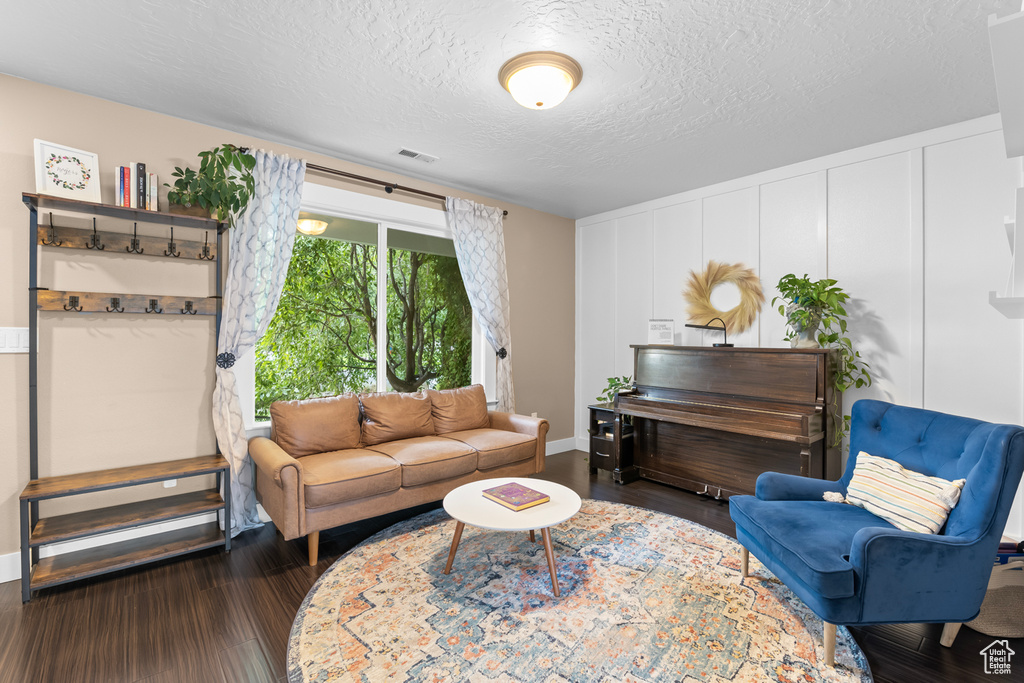 Living room featuring a textured ceiling and dark hardwood / wood-style flooring