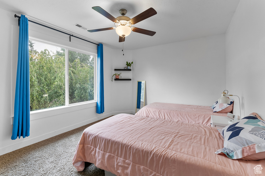 Carpeted bedroom featuring ceiling fan