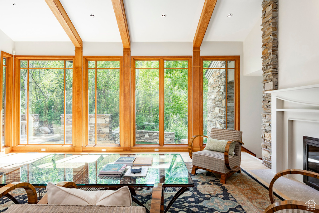Living room with a stone fireplace and beam ceiling