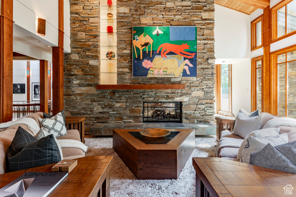 Living area with high vaulted ceiling and a stone fireplace