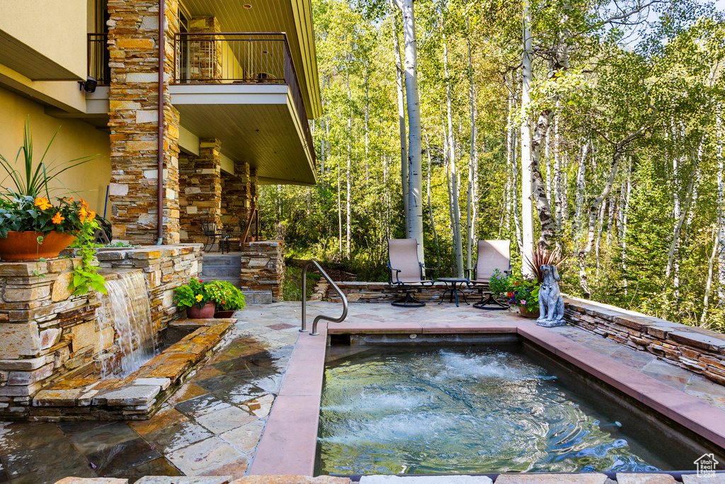 Exterior space with a jacuzzi and a balcony