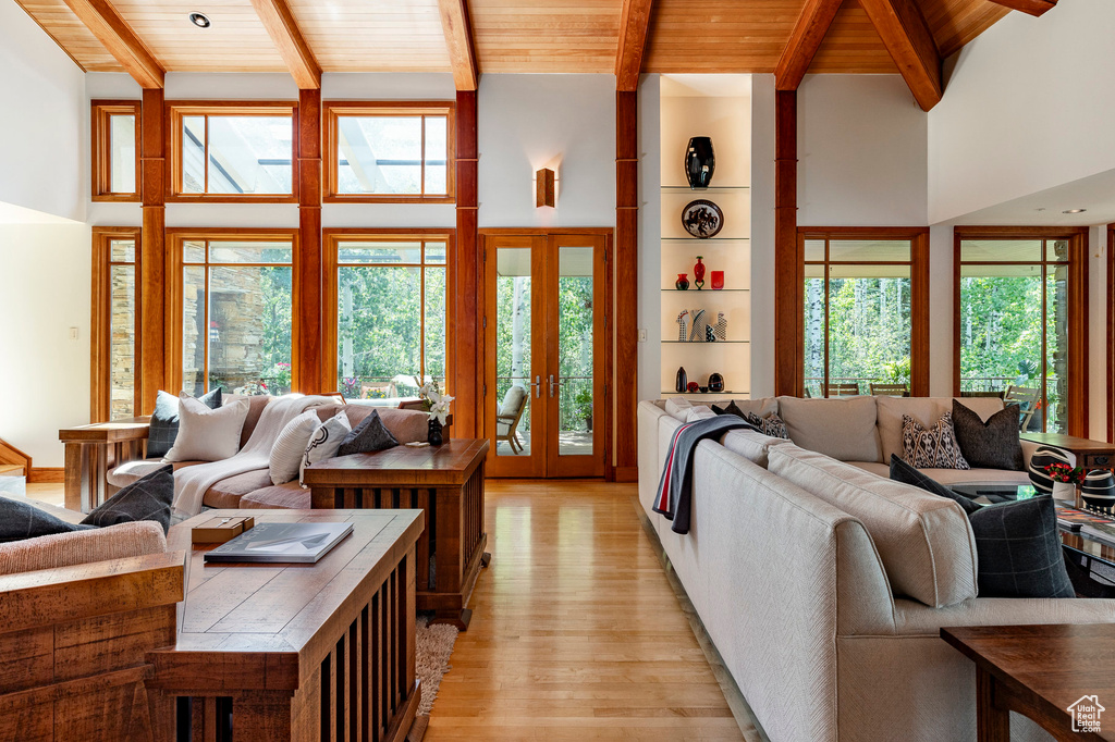 Living room with light wood-type flooring, wooden ceiling, beam ceiling, and a wealth of natural light