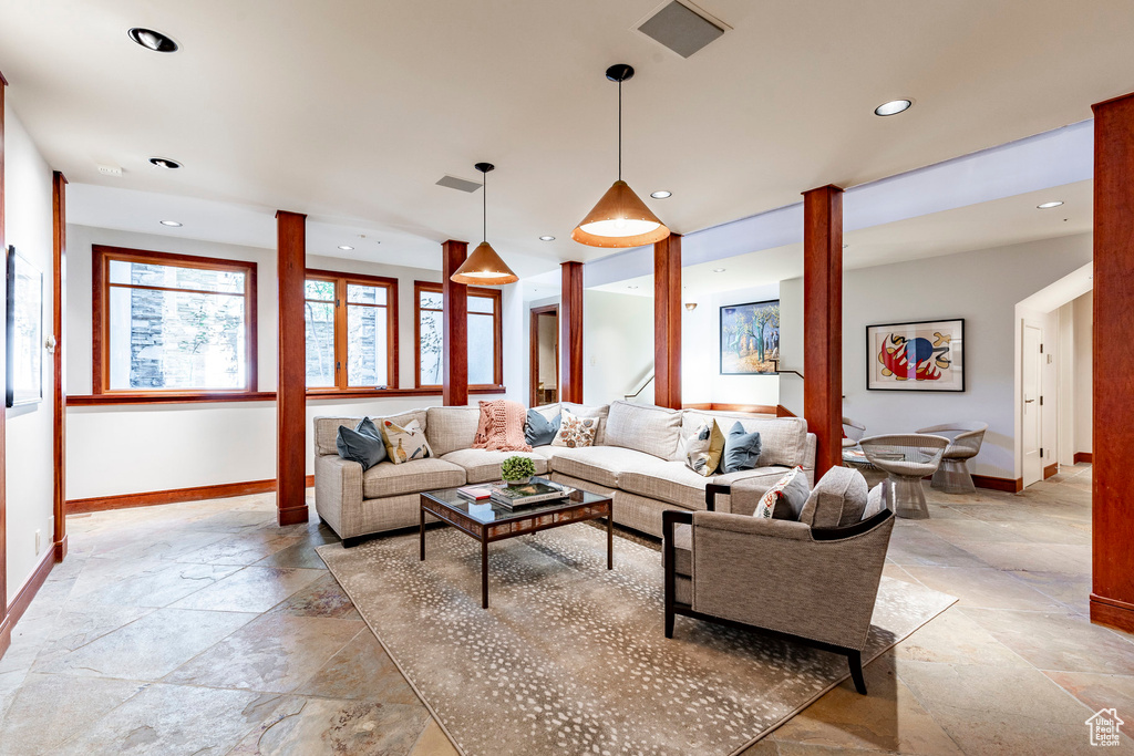 Living area with stone tile flooring, baseboards, and recessed lighting
