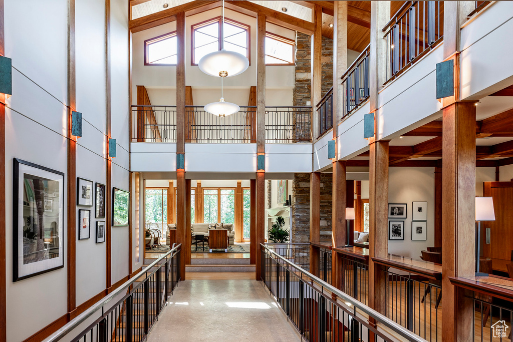 Corridor featuring a towering ceiling and healthy amount of natural light