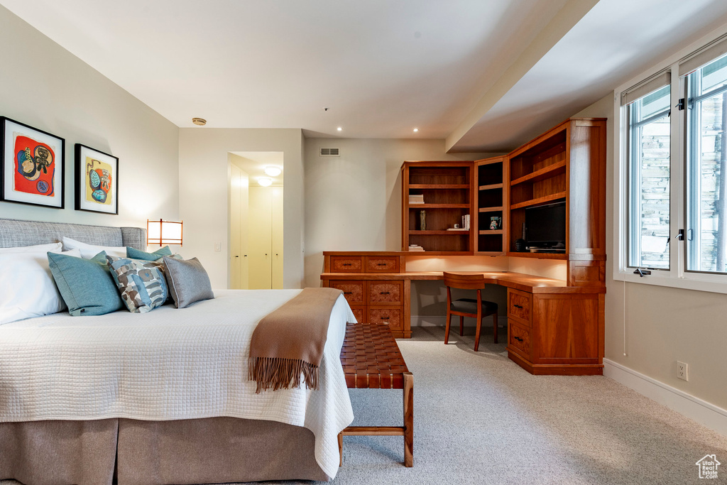Carpeted bedroom with recessed lighting, built in study area, visible vents, and baseboards