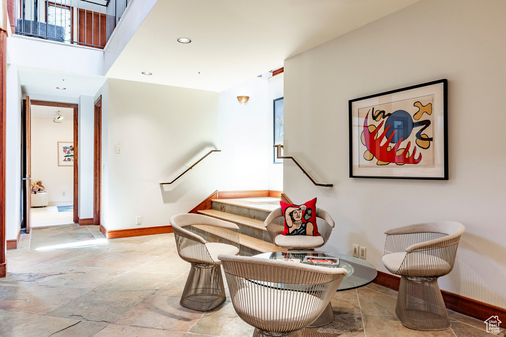Sitting room with stone tile flooring, baseboards, and recessed lighting