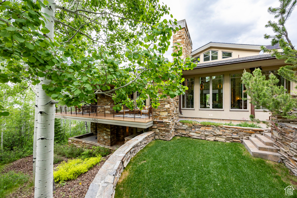View of grassy yard with a deck