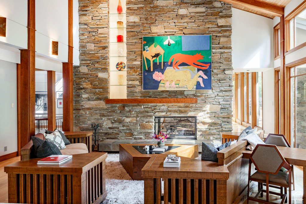 Living room featuring high vaulted ceiling, a fireplace, and wood finished floors