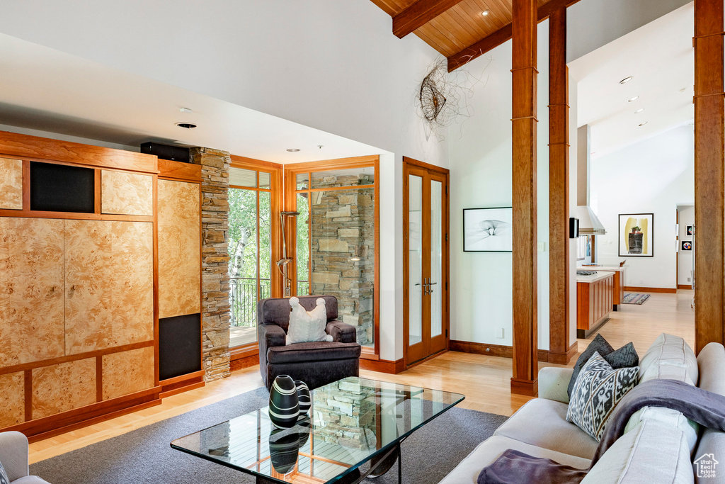 Living room with light wood-style floors, high vaulted ceiling, a wood ceiling with exposed beams, and recessed lighting
