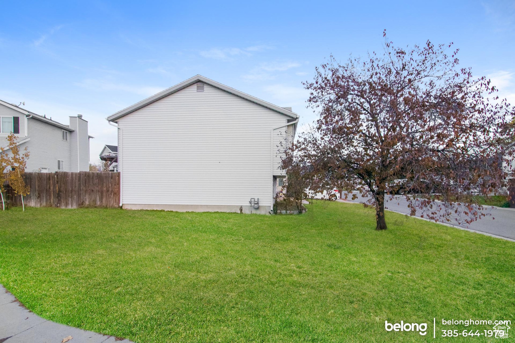 View of side of property featuring a lawn