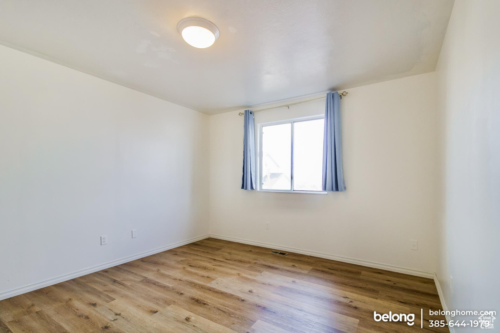 Empty room with light hardwood / wood-style flooring