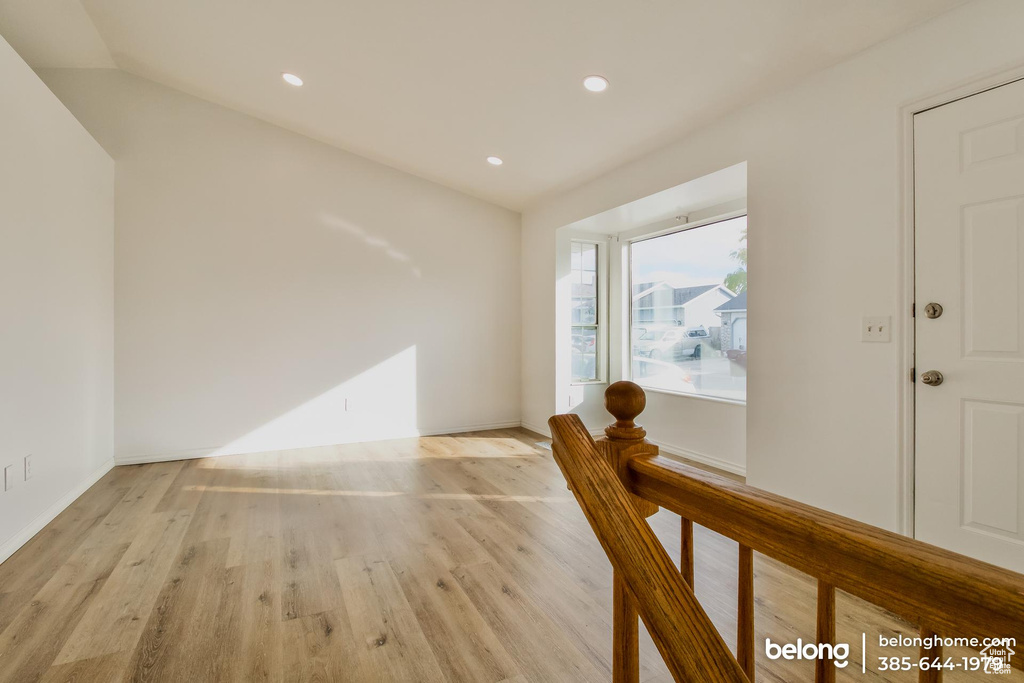 Unfurnished room with lofted ceiling and light wood-type flooring