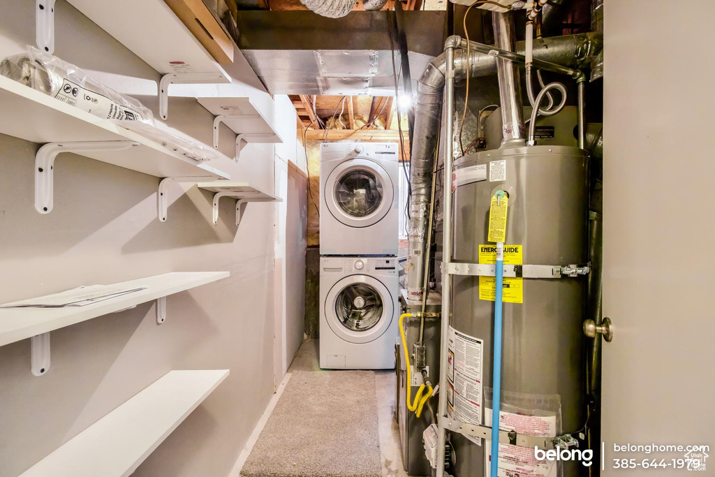 Laundry room with stacked washer and clothes dryer, strapped water heater, and carpet