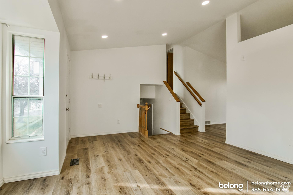 Interior space with lofted ceiling, a wealth of natural light, and light hardwood / wood-style floors