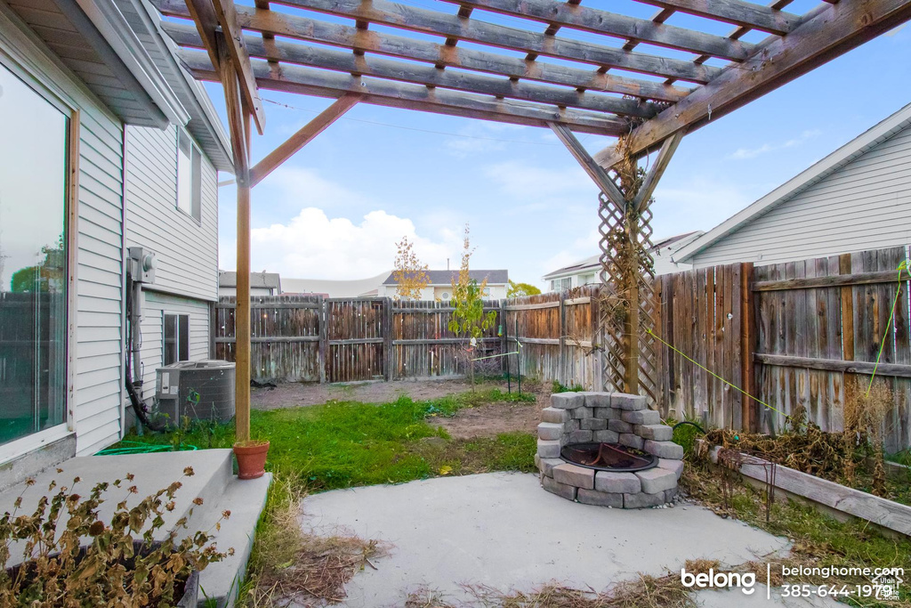 View of yard featuring a pergola, a patio area, and central AC