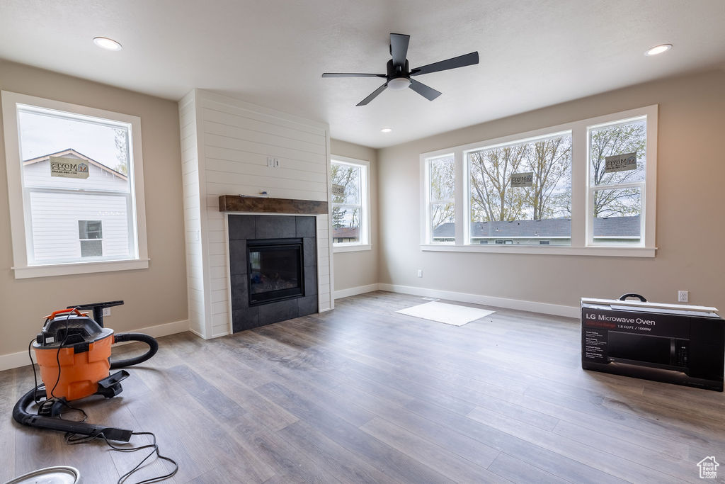 Living room featuring ceiling fan, a tile fireplace, and hardwood / wood-style flooring