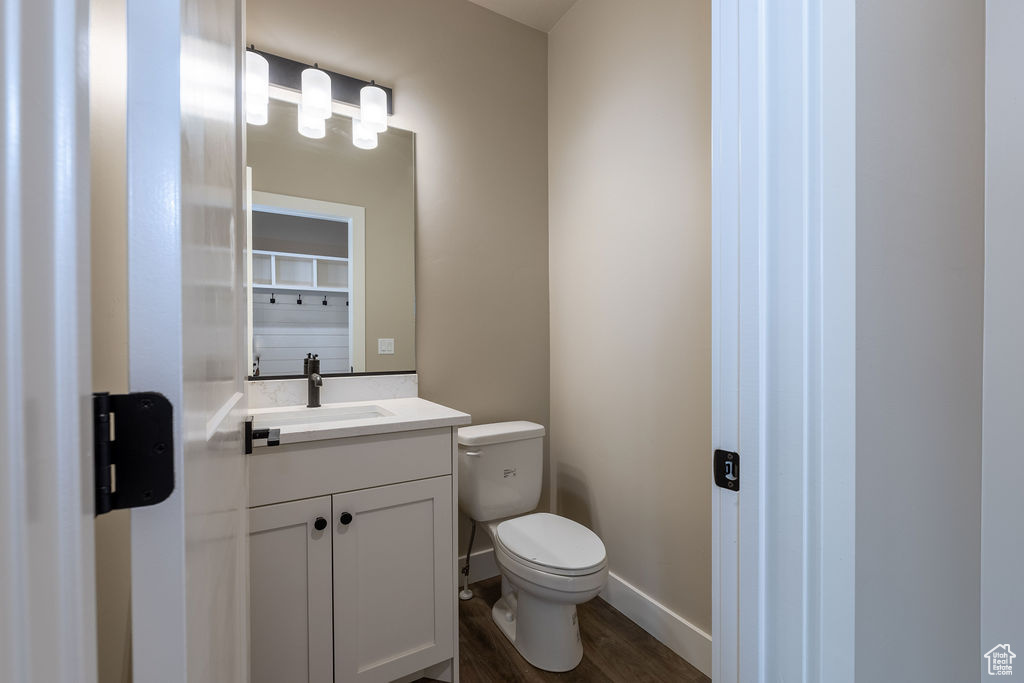 Bathroom featuring vanity, toilet, and hardwood / wood-style flooring