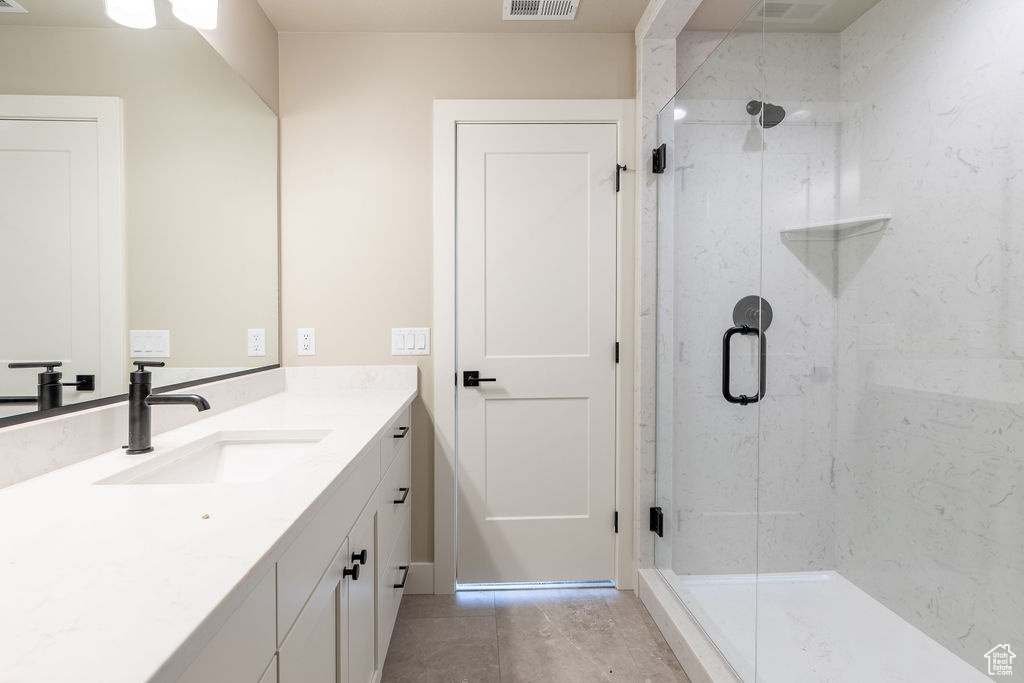 Bathroom featuring an enclosed shower and vanity