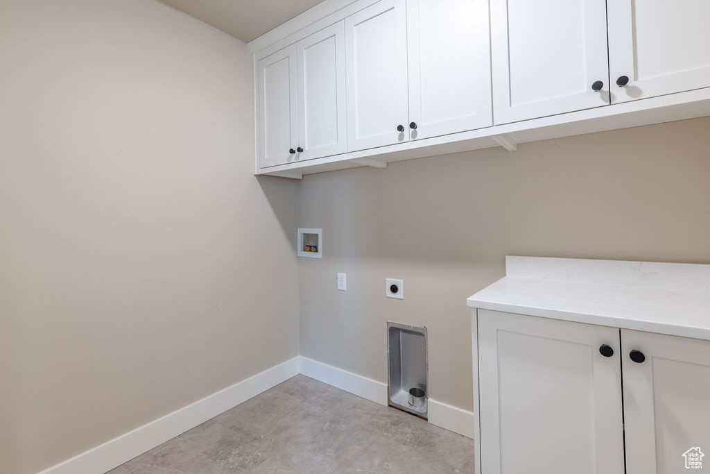 Washroom with cabinets, electric dryer hookup, and washer hookup