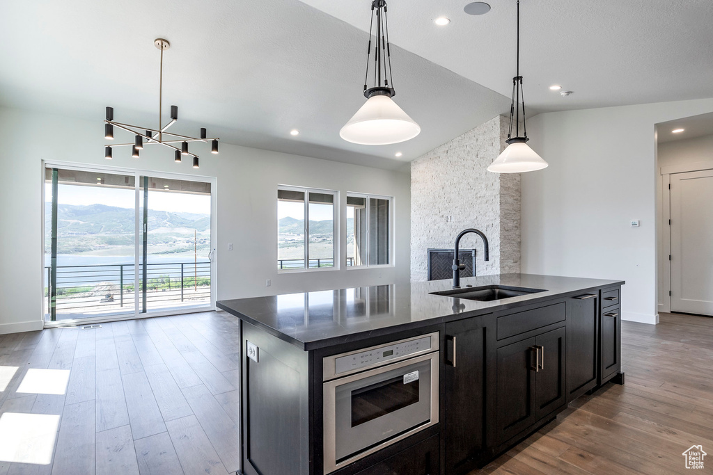 Kitchen with a kitchen island with sink, a wealth of natural light, sink, and hanging light fixtures