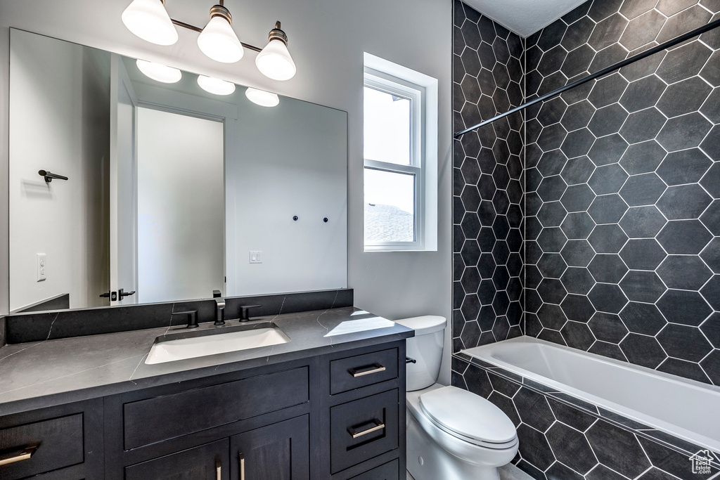 Full bathroom featuring vanity, toilet, and tiled shower / bath