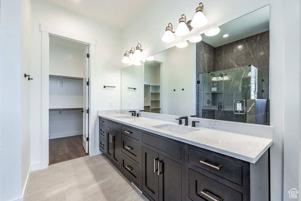 Bathroom featuring hardwood / wood-style floors, an enclosed shower, and vanity