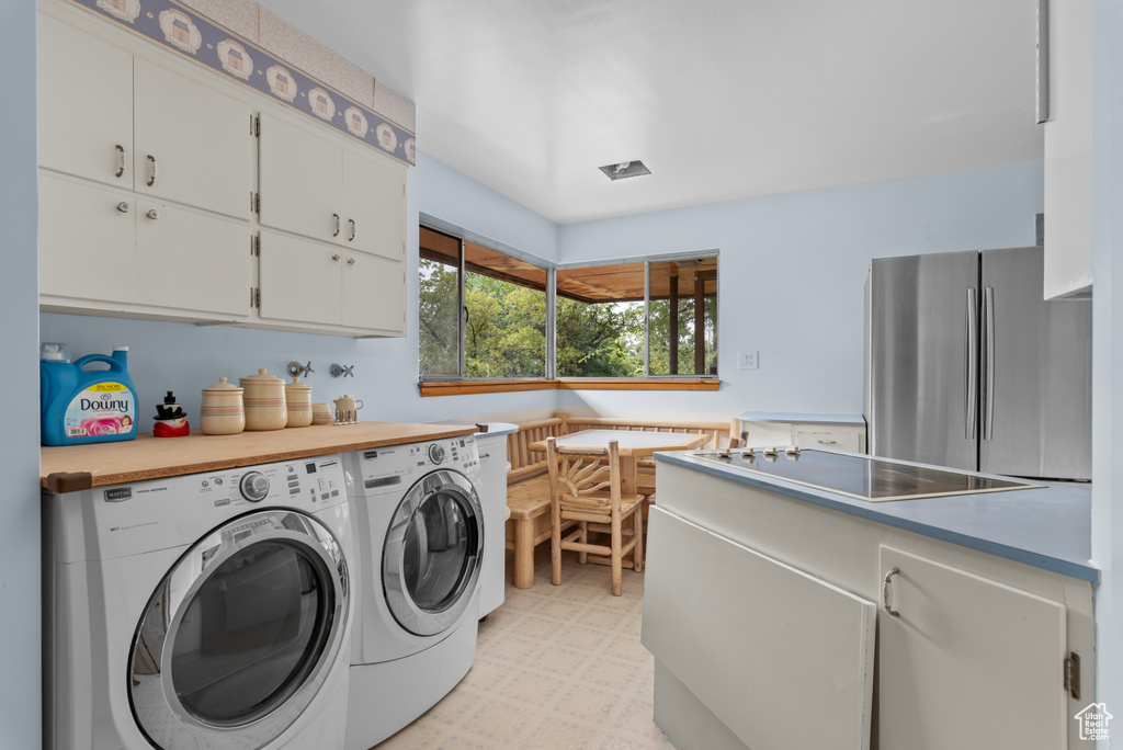 Laundry area featuring cabinets and washing machine and dryer