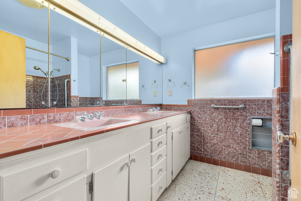 Bathroom featuring tile walls and vanity