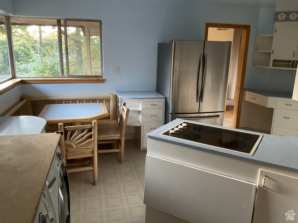 Kitchen featuring stovetop and stainless steel fridge