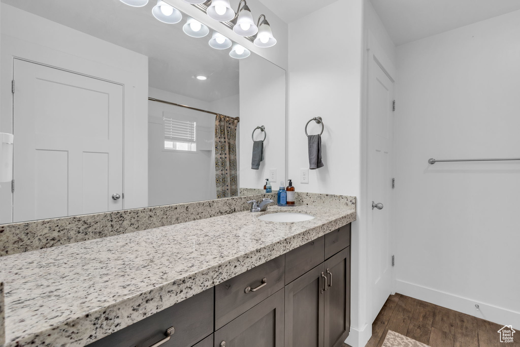 Bathroom featuring vanity, hardwood / wood-style flooring, and walk in shower