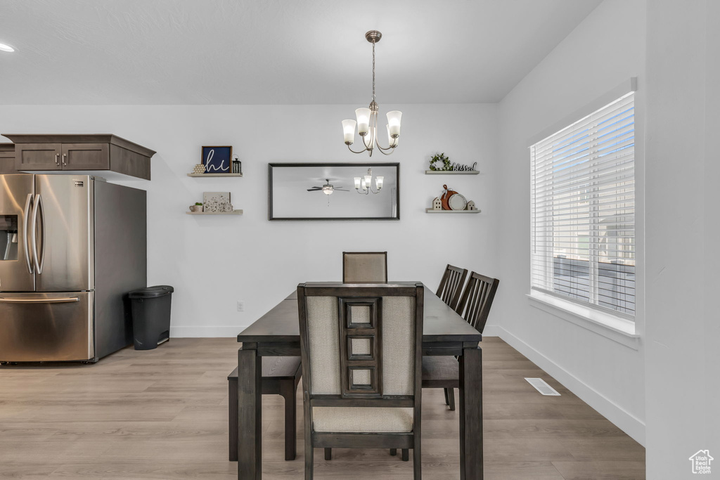 Dining area featuring a notable chandelier and light hardwood / wood-style floors