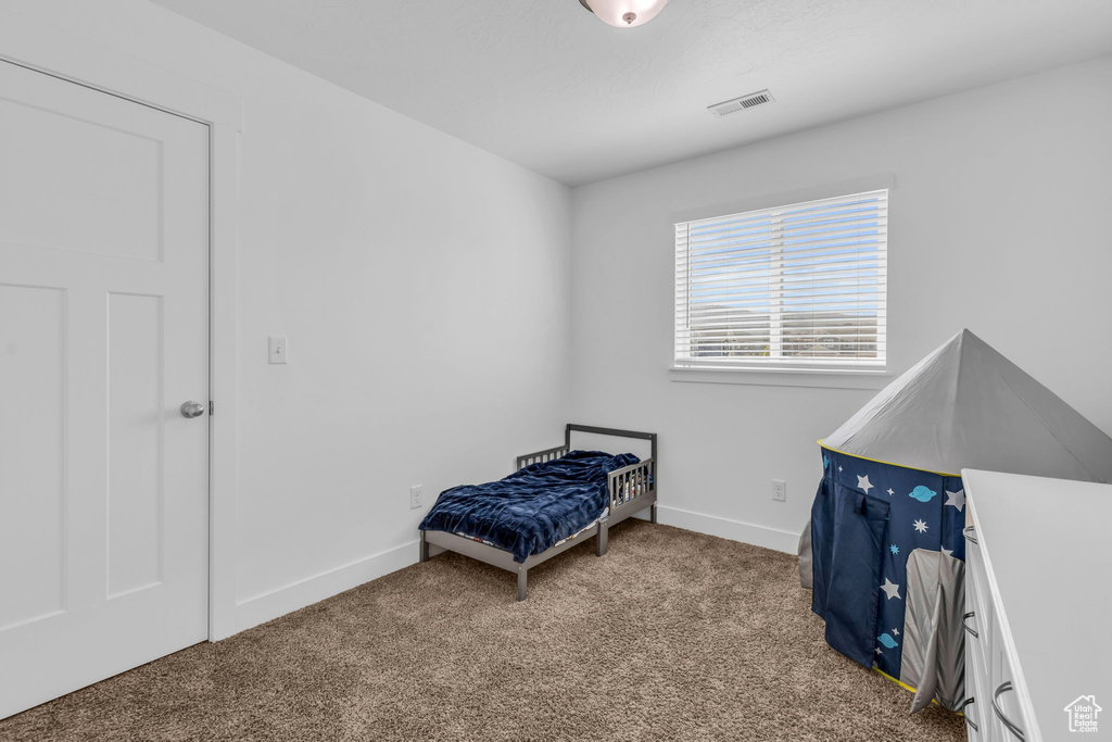 Bedroom featuring light colored carpet