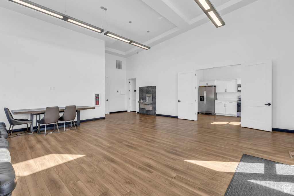 Living room with a towering ceiling and wood-type flooring