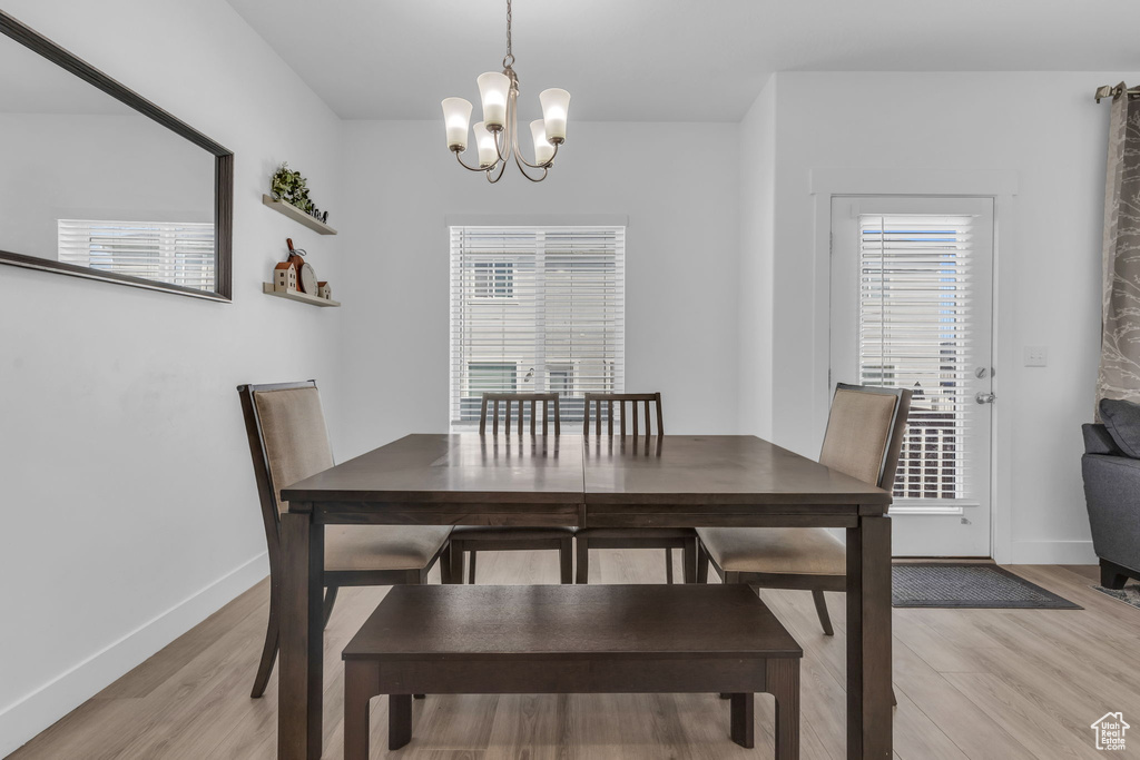 Dining area with light hardwood / wood-style flooring and a chandelier