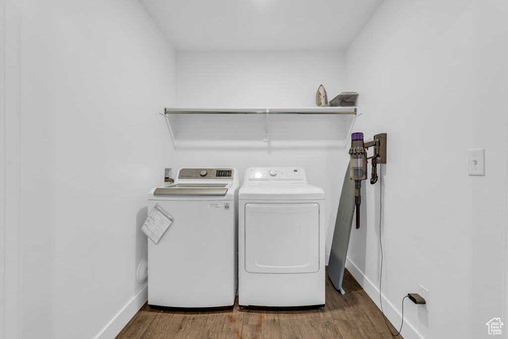 Washroom featuring hardwood / wood-style floors and washing machine and dryer