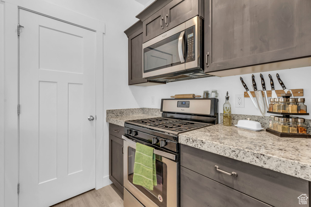 Kitchen featuring light hardwood / wood-style flooring, stainless steel appliances, and dark brown cabinets