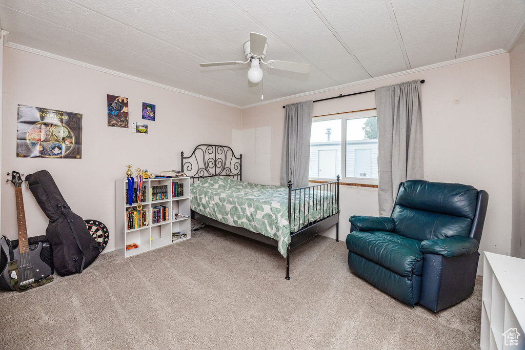 Carpeted bedroom with ornamental molding, a textured ceiling, and ceiling fan