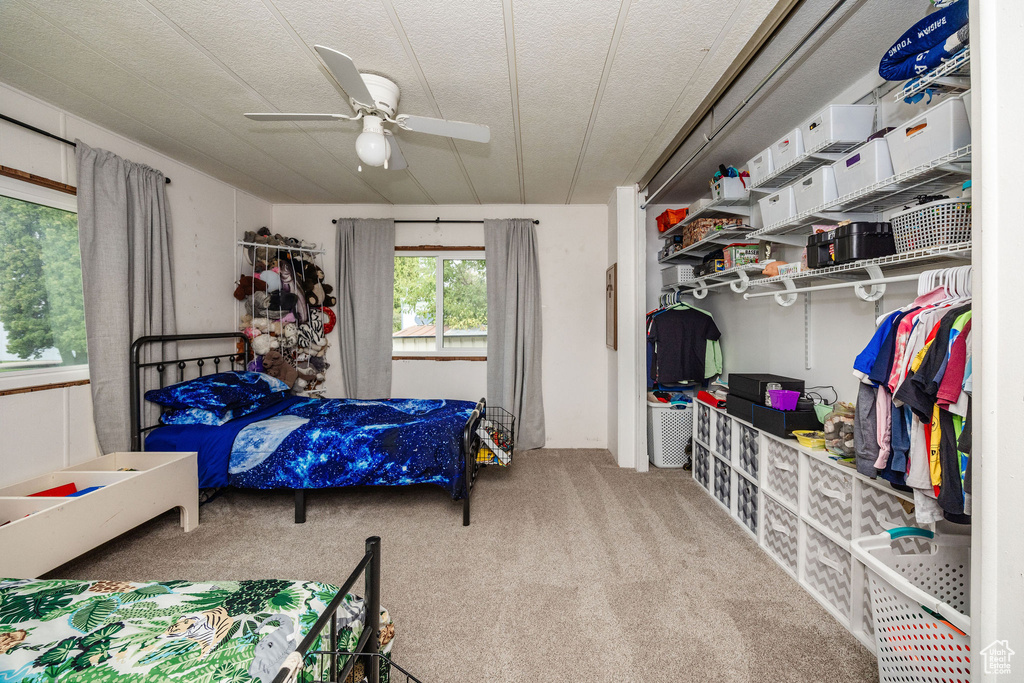 Bedroom featuring a textured ceiling, ceiling fan, and carpet