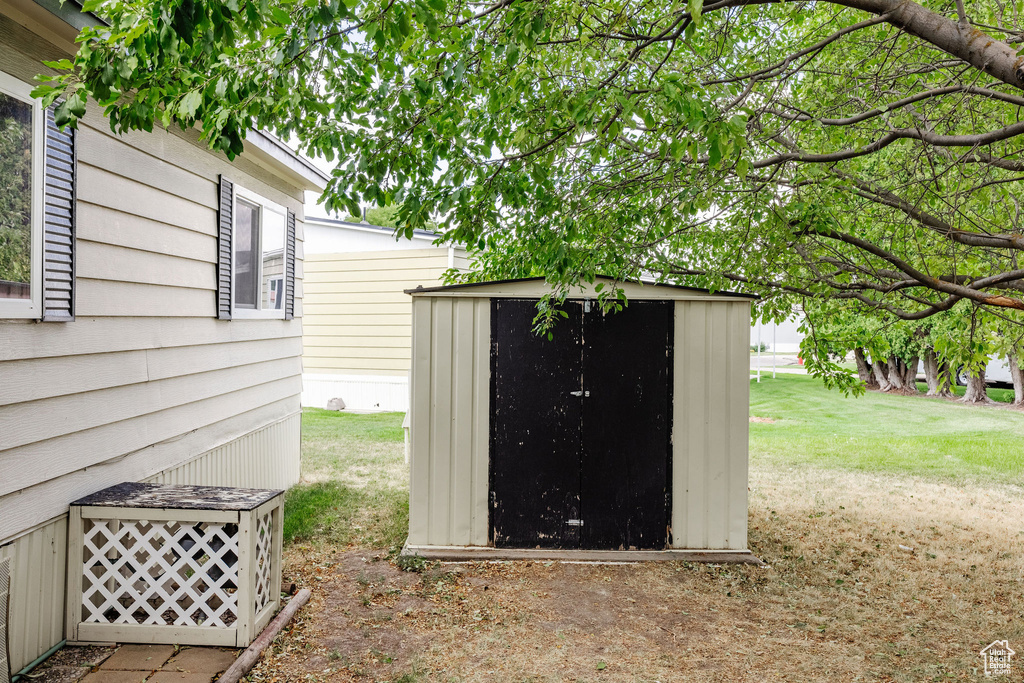 View of outdoor structure featuring a lawn