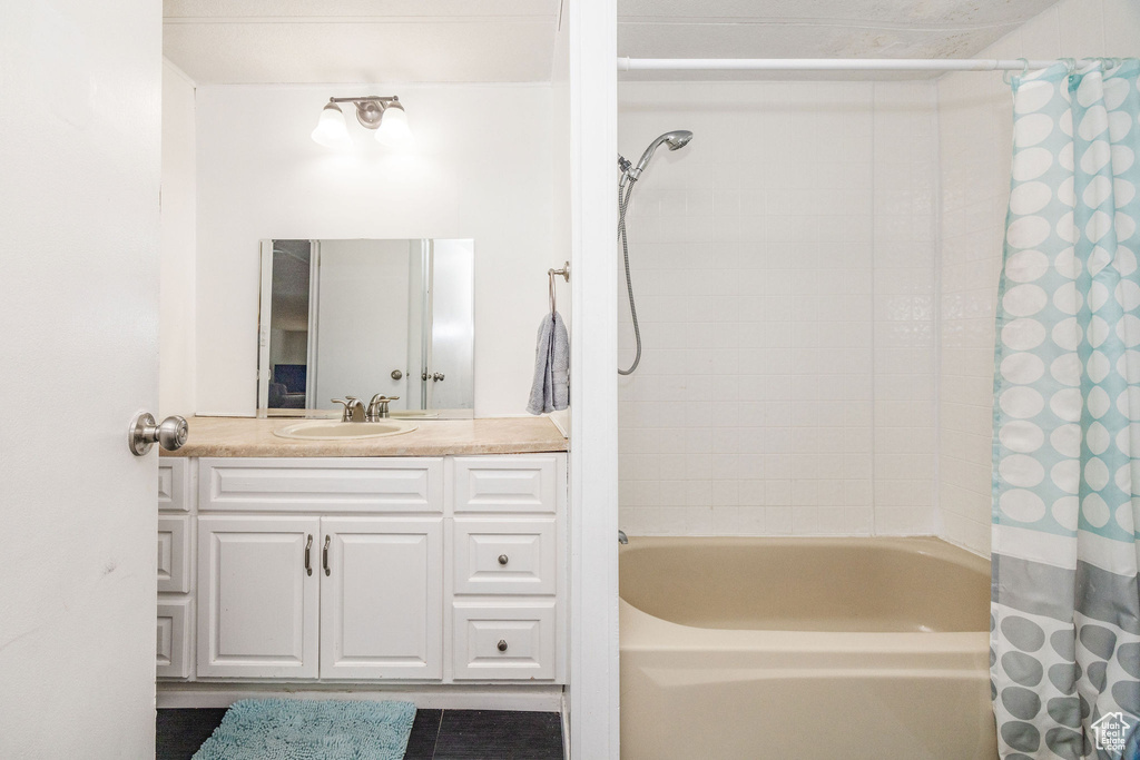 Bathroom with vanity and shower / tub combo with curtain