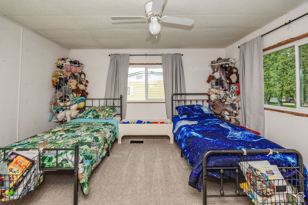 Carpeted bedroom featuring ceiling fan